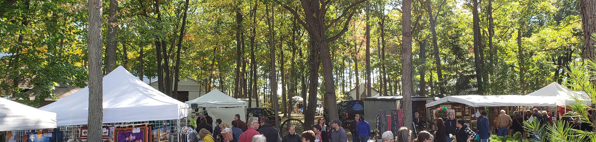 Visitors and vendor tents amongst the autumn oak savanna backdrop.