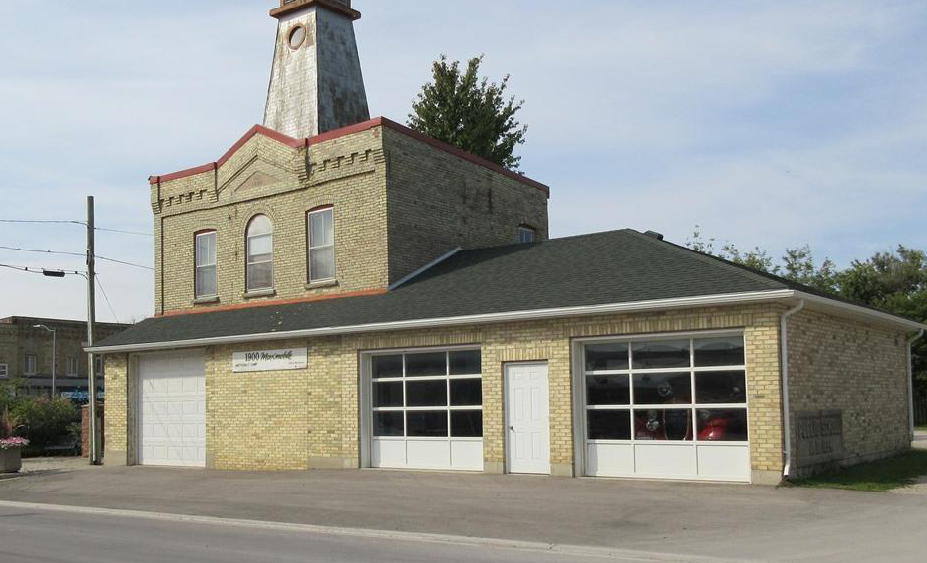 yellow brick building with two large white garage doors.